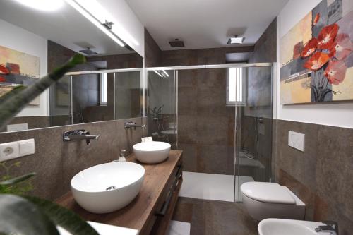 a bathroom with two sinks and a shower at CityChalet romantic Bozen in Bolzano