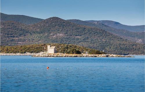 a person swimming in a lake with mountains in the background at 3 Bedroom Awesome Apartment In Klek in Klek