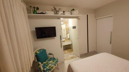 1 dormitorio con 1 cama y TV en la pared en Solar Água Pipa 119, en Pipa