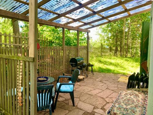 a patio with a pergola with chairs and a table at Charmig stuga av rustik stil i Stockholms område in Stockholm
