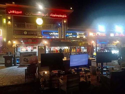 a bar at night with a large monitor in front at Chalet in Bluebay Asia Resort Ain Sokhna in Ain Sokhna