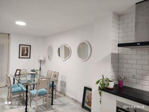 ein Esszimmer mit einem Tisch und Spiegeln an der Wand in der Unterkunft Casa Trebol Parquing Gratis in Estepona