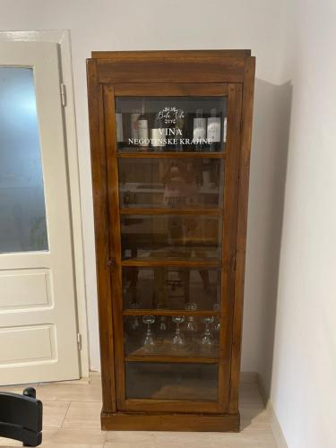 a wooden cabinet with glass shelves next to a door at BELA VILA in Negotin