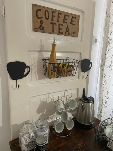 a table with cups and a coffee and tea at BELA VILA in Negotin