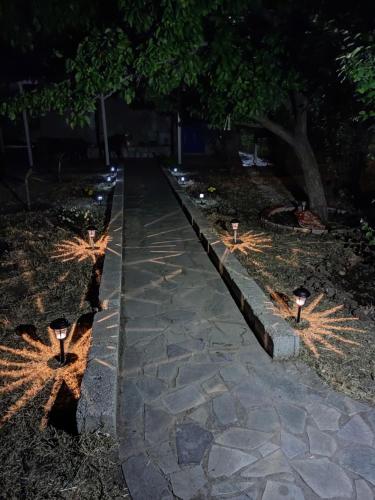 Una pasarela con luces en el suelo por la noche en Nemesia resort en Anaxos