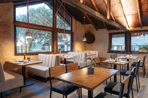 un restaurante con mesas, sillas y ventanas en Chilcabamba Lodge, en Machachi