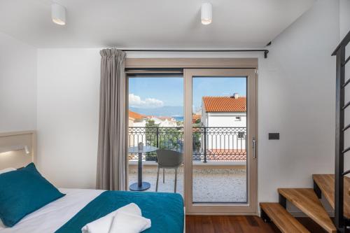 1 dormitorio con cama y vistas a un balcón en Vila Iris Baška, en Baška