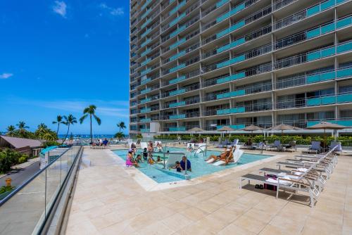 a large apartment building with a swimming pool and people in it at Ilikai Hotel in Honolulu