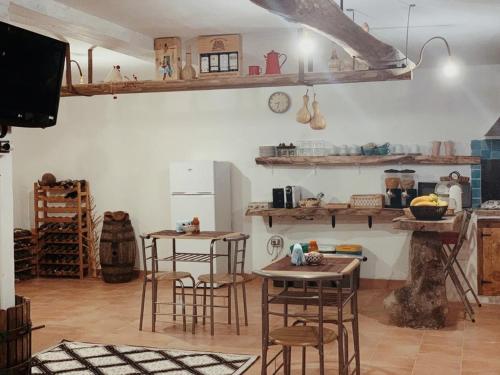 una cocina con taburetes de madera y mesas en una habitación en B&B S’ Orgiola, en Girasole