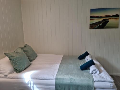 a white bed with pillows on it in a room at Bårdshaug studio apartment in Orkanger