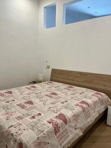 ein Schlafzimmer mit einem Bett mit einer Decke darauf in der Unterkunft A casa di Alessandra in Mailand