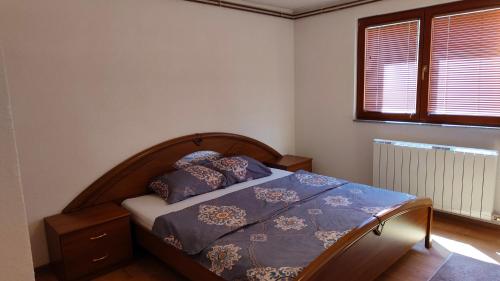 a bedroom with a bed with purple sheets and a window at ENSA Apartments in Dubrave Gornje