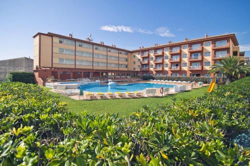 a hotel with a swimming pool in front of a building at RVApartaments Estartit Confort in L'Estartit