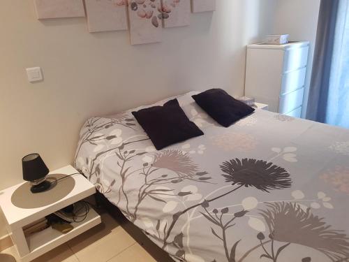 um quarto com uma cama e uma mesa de cabeceira com uma cama sidx sidx em Beau appartement avec garage fermé em Beausoleil