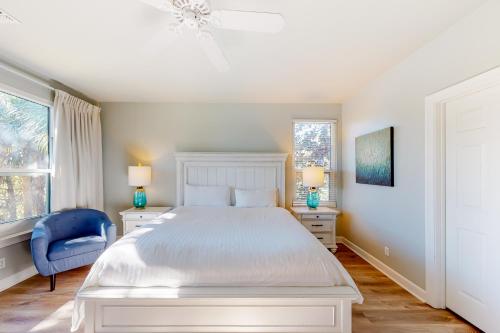 1 dormitorio blanco con 1 cama y 1 silla azul en Turnberry Villas #8562 en Destin