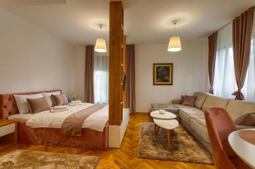 um quarto com uma cama grande e um sofá em Apartmani Stojanović Zlatibor em Zlatibor