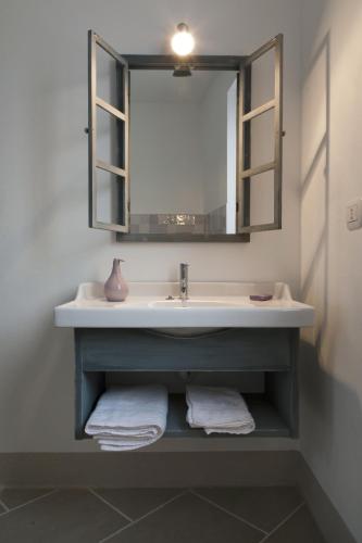 ein Badezimmer mit Waschbecken, Spiegel und Handtüchern in der Unterkunft Crealto in Alfiano Natta