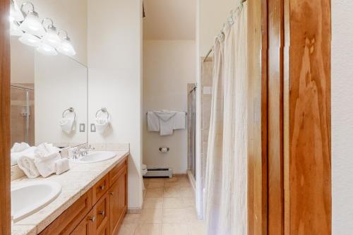 une salle de bain avec deux lavabos et une douche dans l'établissement Antlers Gulch #304, à Keystone