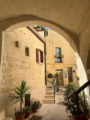 an archway leading to a building with stairs and plants at La Casetta in Altamura