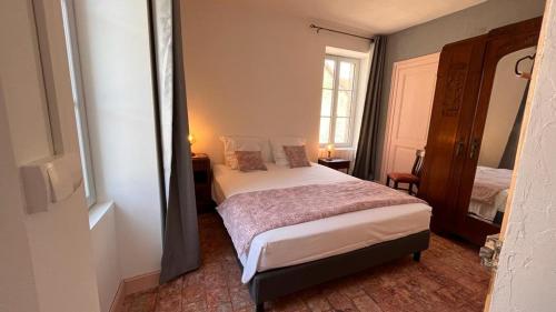 a small bedroom with a bed and a window at Chez Loulou - La suite in Lainsecq
