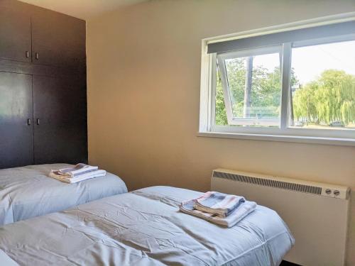 2 camas en una habitación con ventana en Sheffield serviced apartment, en Greenhill