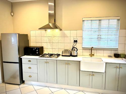uma cozinha com um frigorífico branco e um lavatório em 31 on Park em Grahamstown