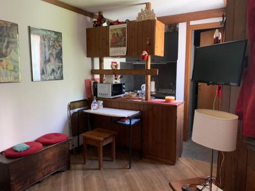 Dieses kleine Zimmer verfügt über einen Schreibtisch, ein Bett und einen TV. in der Unterkunft renovated studio ski in ski out, CIR 0282 in Breuil-Cervinia