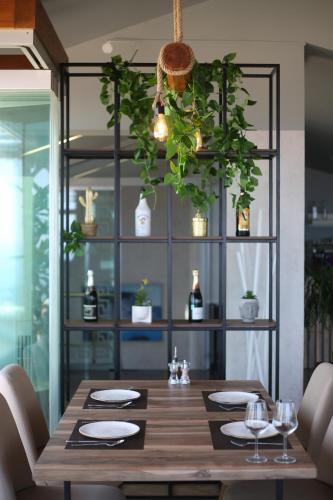 a dining room with a table with plants on it at Aliko Hotel in Vlorë