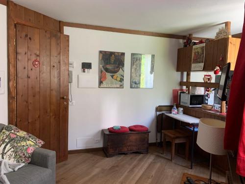 ein Wohnzimmer mit einem Sofa, einem Schreibtisch und einem Tisch in der Unterkunft renovated studio ski in ski out, CIR 0282 in Breuil-Cervinia