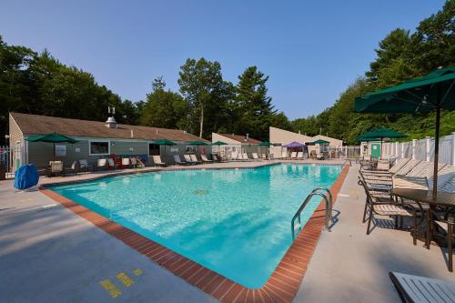 a large swimming pool with chairs and umbrellas at Moody Beach Camping Resort 28 ft. Park Model 6 in Moody