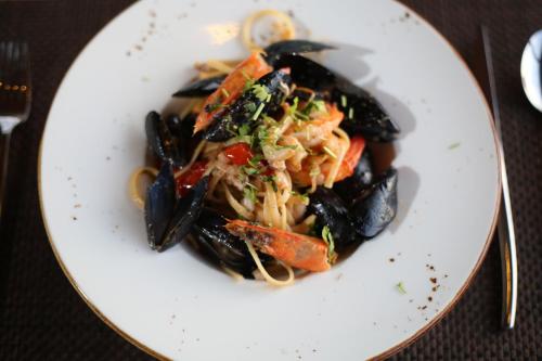 a plate of food with mussels on a table at Aliko Hotel in Vlorë