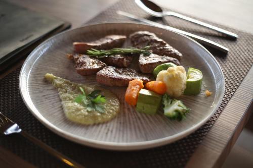 a plate of food with meat and vegetables on a table at Aliko Hotel in Vlorë
