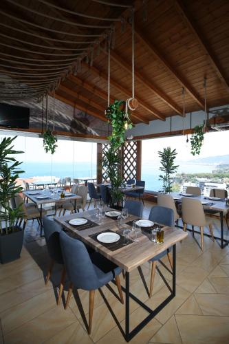 a dining room with tables and chairs and the ocean at Aliko Hotel in Vlorë