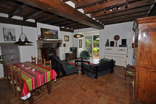 un salon avec une table et une cheminée dans l'établissement Gîte proche Puy du Fou, à Mortagne-sur-Sèvre