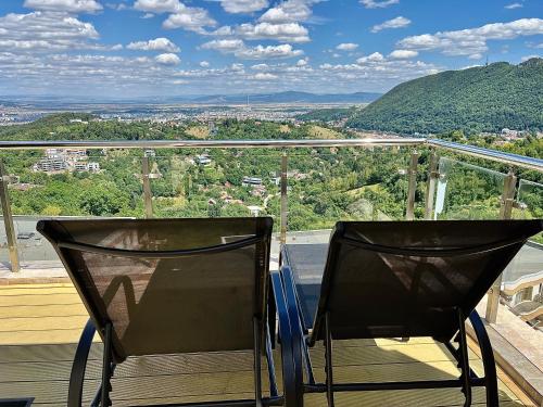 a pair of chairs sitting on top of a balcony at Seasons-Top of the city in Braşov