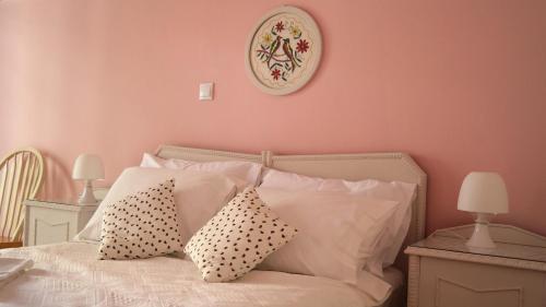 a bedroom with pink walls and a bed with pillows at Flat in the heart of Koukaki under Acropolis in Athens