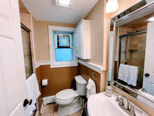 a bathroom with a toilet and a sink and a window at Luxury Executive Suite Harvard Allston 3 Bedrooms 2 Baths in Boston