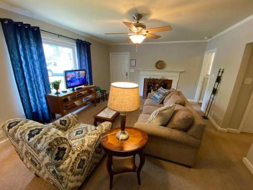 a living room with a couch and a table with a lamp at Charming Condo Near Downtown, NCSU and PNC Arena in Raleigh