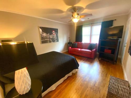 a bedroom with a bed and a living room with a couch at Charming Condo Near Downtown, NCSU and PNC Arena in Raleigh
