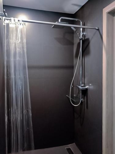 a shower in a bathroom with a shower curtain at Onkel Inn Apart Suites in La Paz