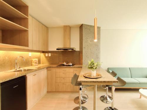 a kitchen with a sink and a table with chairs at Onkel Inn Apart Suites in La Paz
