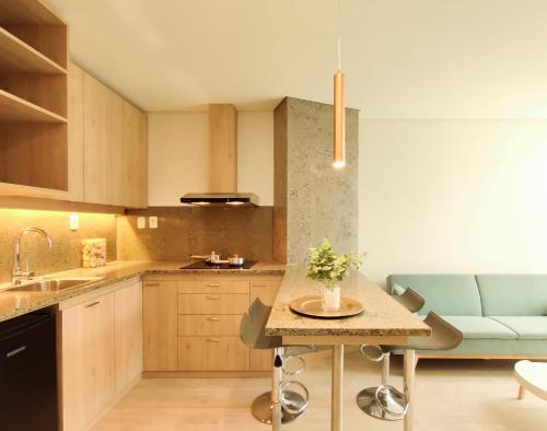 a kitchen with a table and a blue couch at Onkel Inn Apart Suites in La Paz