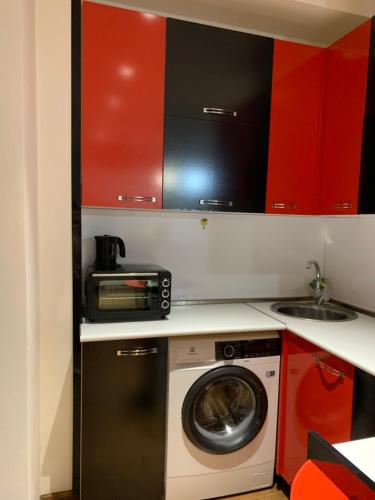 a kitchen with a washing machine and a microwave at City Central Apartment in Yerevan