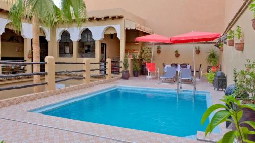 een zwembad op een binnenplaats met een tafel en stoelen bij Riad Benyara in Taroudant