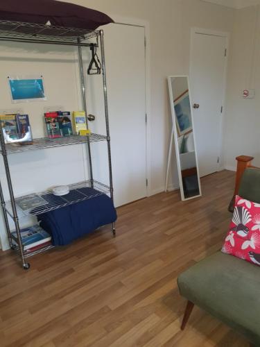 a room with a bunk bed and a chair at Bluewater Studio in Tairua