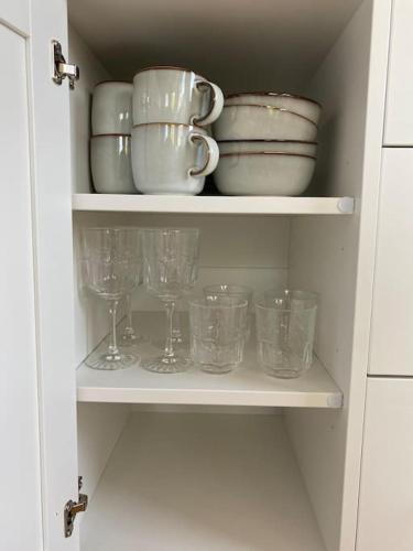 a cupboard with dishes and glasses on it at Adorable Cabin in the Countryside in Portlaoise