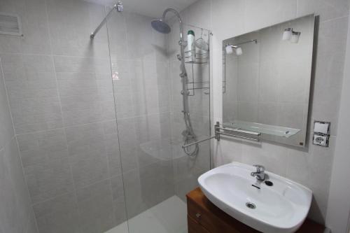 a bathroom with a sink and a glass shower at Amazing views of Cabo de las Huertas. 1 min walk Cabo de las Huertas beach. 4 mins walk Playa de San Juan beach in Alicante