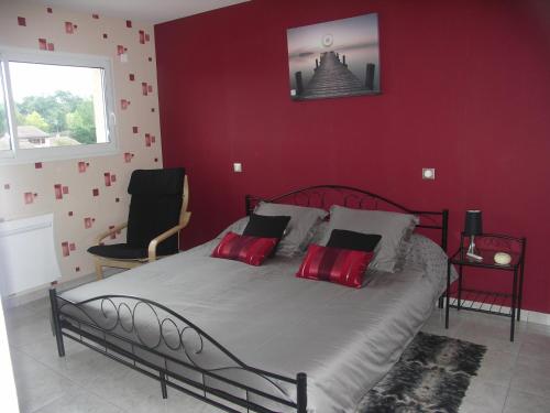 Schlafzimmer mit einem großen Bett mit roten Wänden in der Unterkunft Chambres d'Hôtes Le Saint Ô Détente in Saint-Orens-de-Gameville
