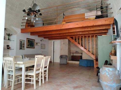 a dining room with a table and chairs and a staircase at B&B Il Caminetto in Matera