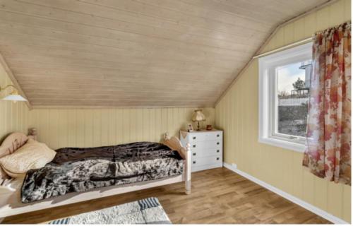 1 dormitorio con cama y ventana en Arendalsuka - Fin enebolig, sentralt og sjønært,gratis parkering 4 rom 3 bad 2 stuer en Arendal